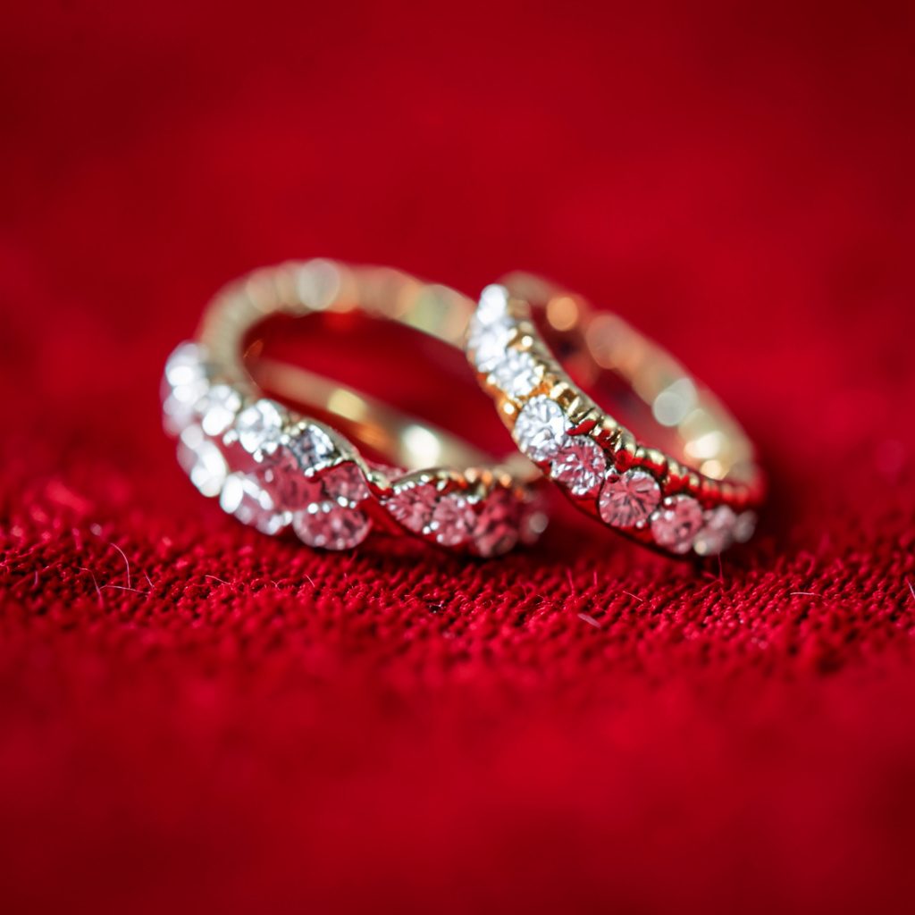 Elegant drop earrings with pearl and crystal details, shown in extreme close-up against a soft blurred backdrop.