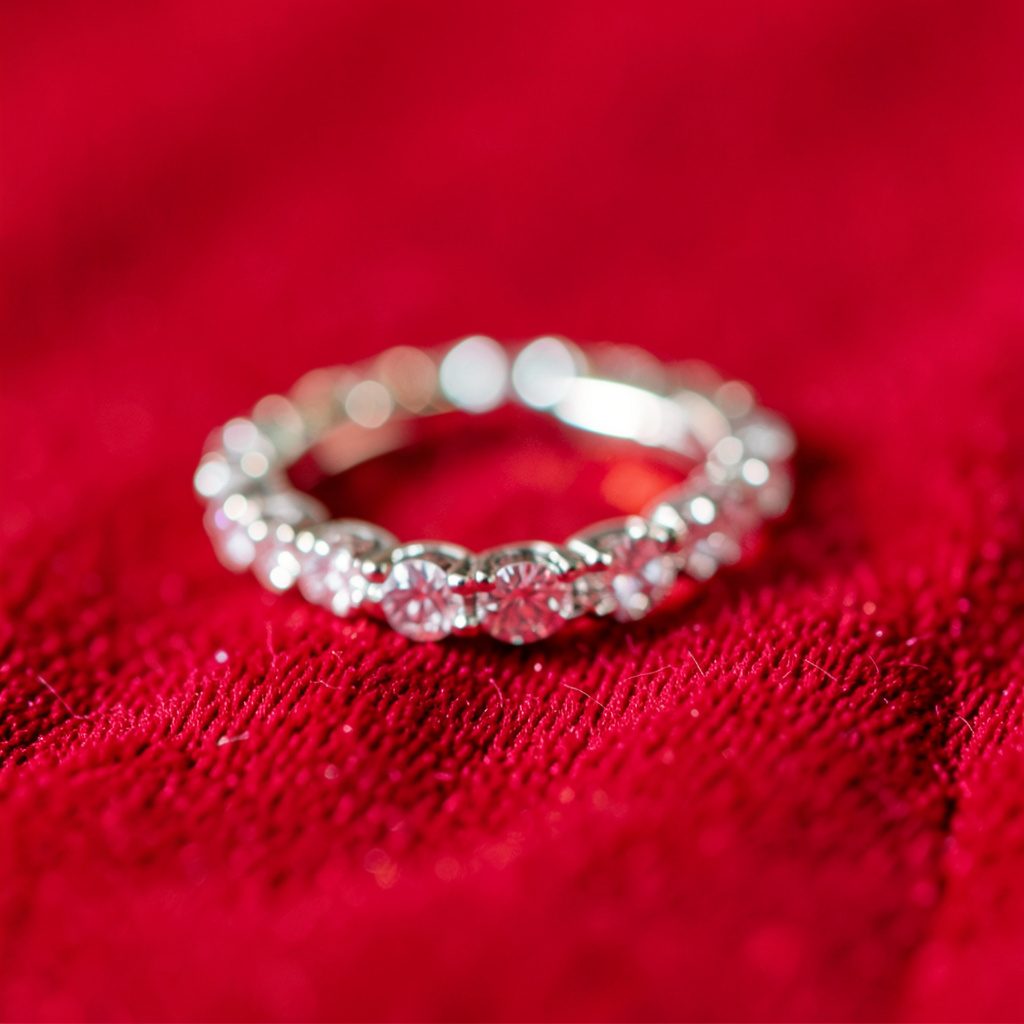 Delicate bridal earrings with a subtle pearl drop, shown in extreme close-up against a soft out-of-focus background.